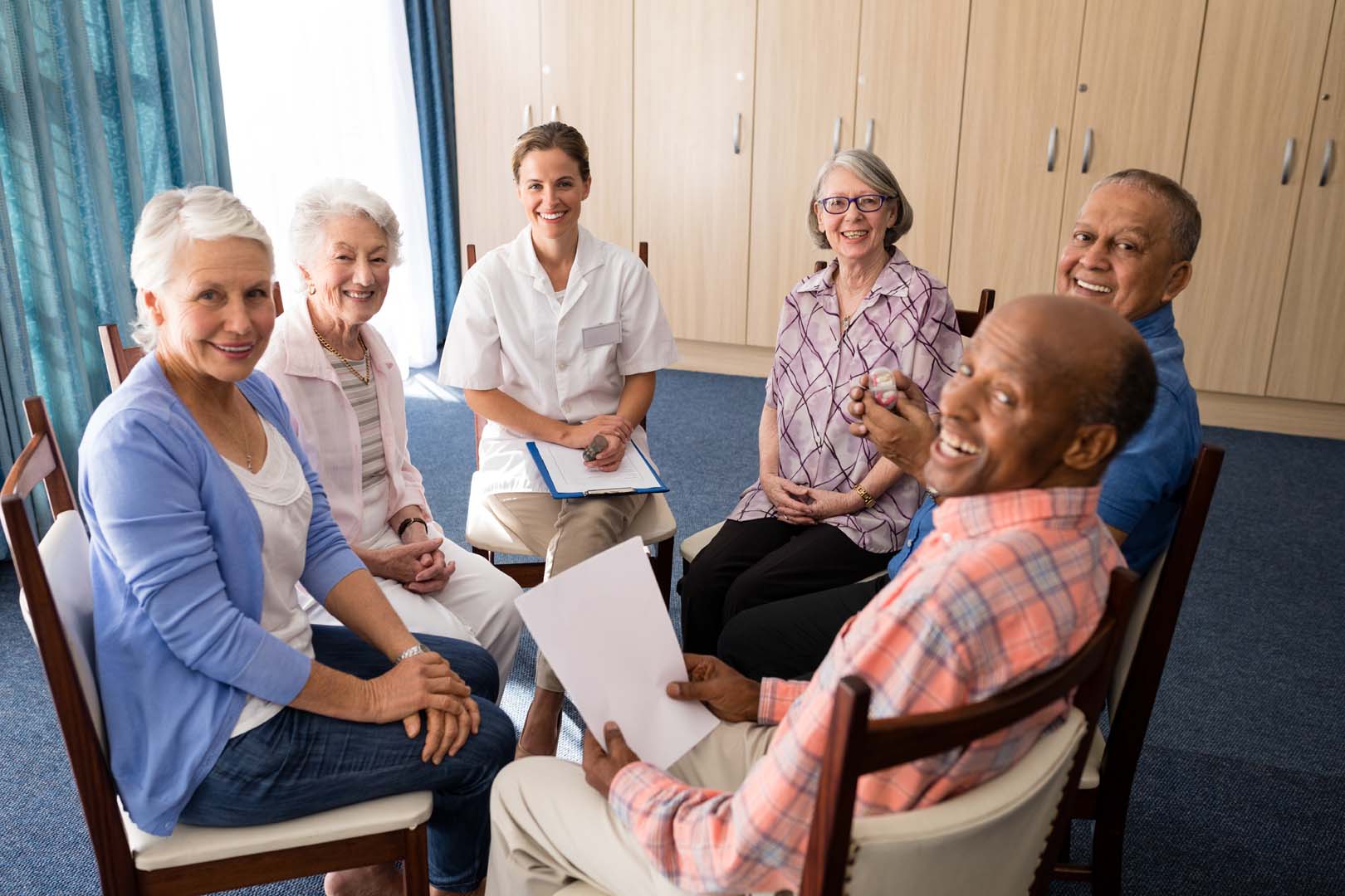 Smiling seniors with a caregiver