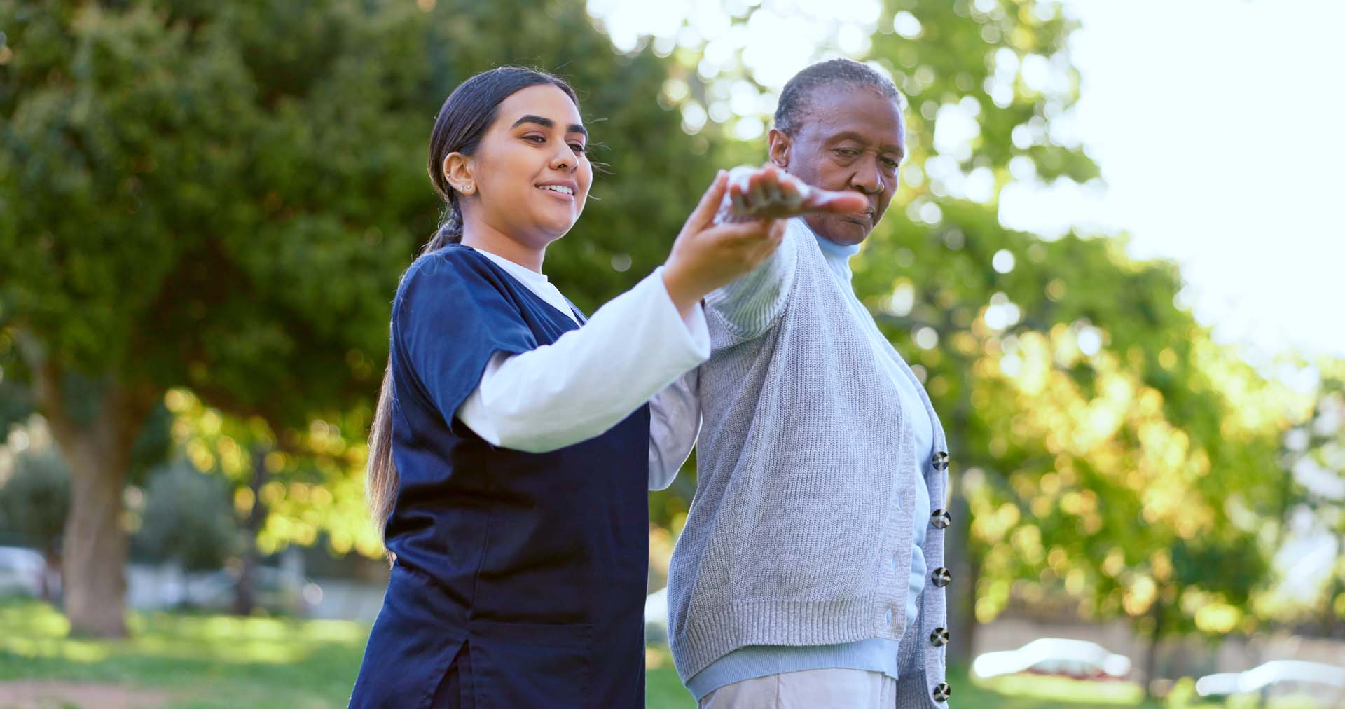 Caregiver helping an elderly woman with stretching