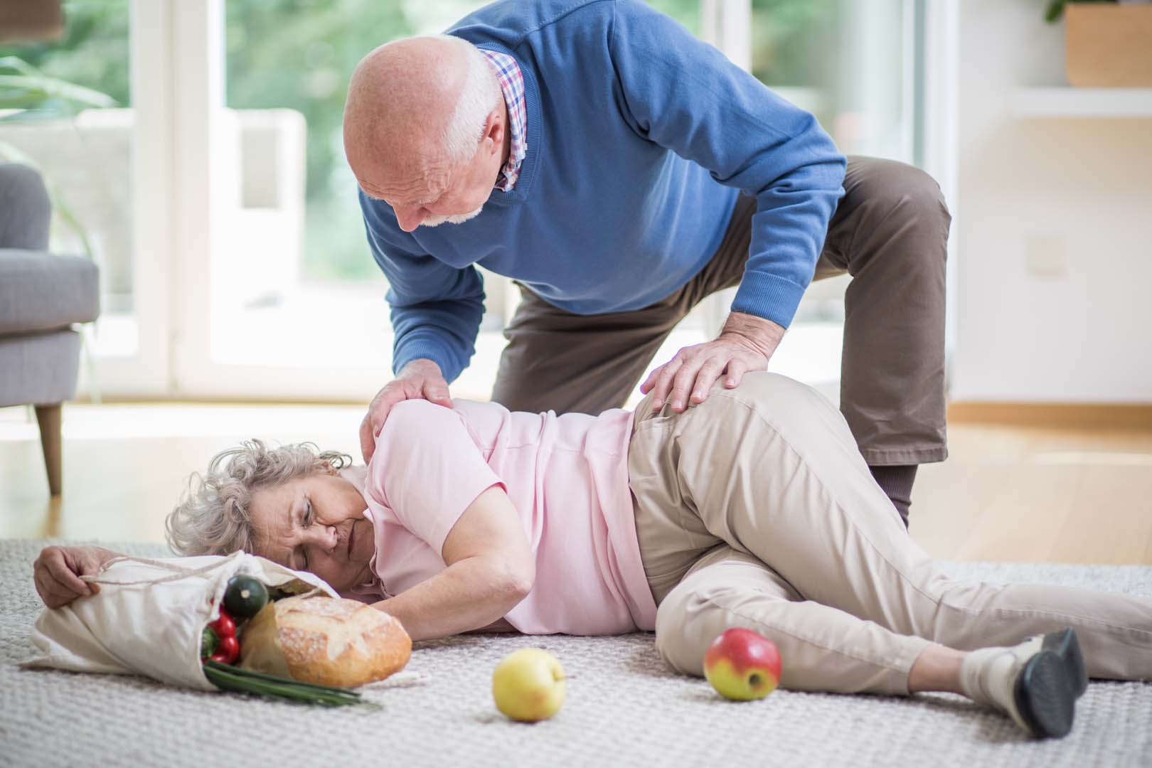 A carer helping a senior who has had a fall at home